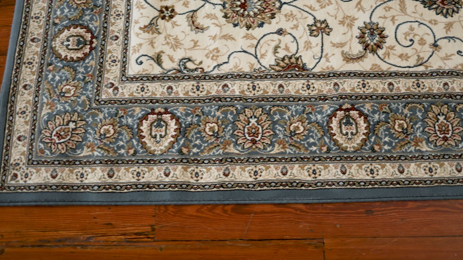 Hazel Ivory/Light Blue rug, filmed on a wood floor