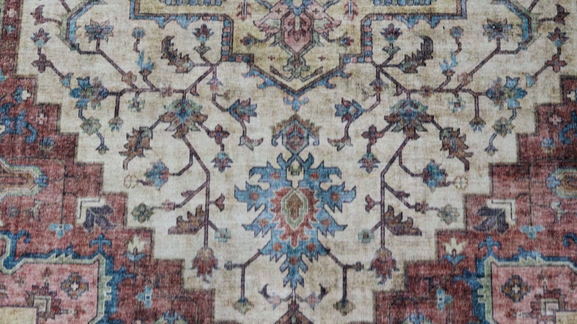 Acadia Red/Blue/Beige rug, filmed on a wood floor